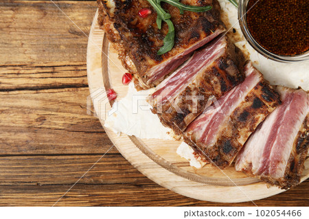 Delicious grilled ribs served on wooden table, top view 102054466