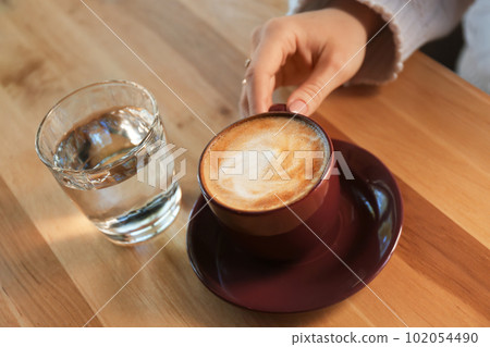 Woman with aromatic coffee at table in cafe, closeup Woman with aromatic coffee at table in cafe, closeup 102054490