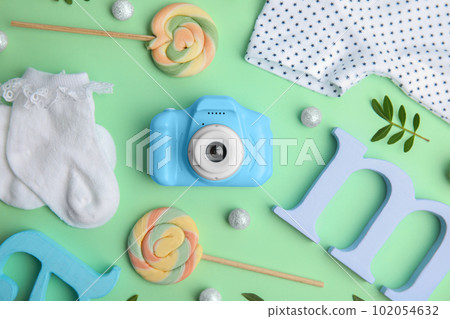 Flat lay composition with toy camera on light green background. Future photographer 102054632