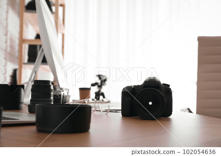 Photographer's workplace with professional camera in office 102054636