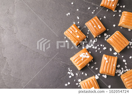 Salted caramel on grey table, flat lay. Space for text 102054724