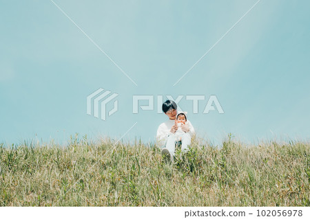 Family photo of dad and child sitting on the bank Family photo of dad and child sitting on the bank 102056978