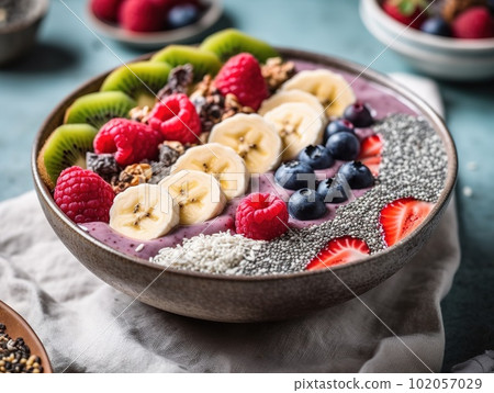 A refreshing, fruit-filled smoothie bowl, brimming with an array of colorful berries, banana slices, and chia seeds. A refreshing, fruit-filled smoothie bowl, brimming with an array of colorful berries, banana slices, and chia seeds. 102057029