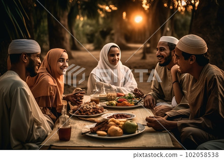 A family sitting together for iftar the breaking of fast at sunset.On the table full of traditional Ramadan foods. The family smiling and laughing. Generative AI A family sitting together for iftar the breaking of fast at sunset.On the table full of traditional Ramadan foods. The family smiling and laughing. Generative AI 102058538