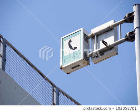 Road sign (information sign) "Emergency phone" and blue sky. 102058701