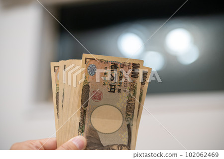 man holding banknotes man holding banknotes 102062469