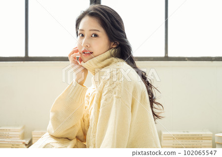 Portrait of a woman wearing a loose turtleneck knit 102065547