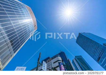 日本東京城市景觀當心中暑和紫外線。從澀谷站前十字路口看到的建築物和太陽 = 4 月 27 日 102070177