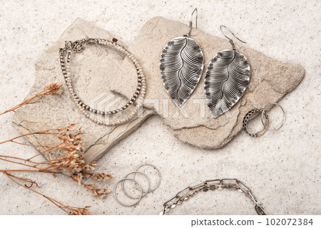 Beautiful Silver and Pearl Jewelry on white stones and sand. Various jewelry - bracelets, necklaces and rings. 102072384