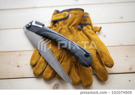 Essential items for camping Leather gloves and a folding saw 102074809