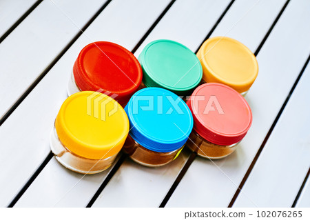 spice storage containers. containers on a white striped table.  102076265