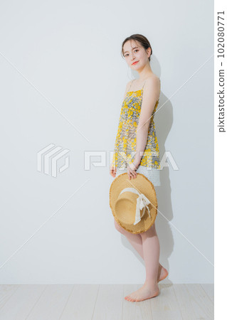A woman holding a straw hat 102080771