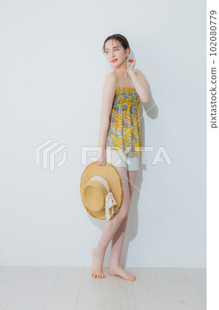 A woman holding a straw hat 102080779
