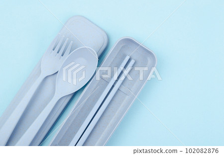 The Plastic spoons, forks and chopsticks kit set on blue background. 102082876