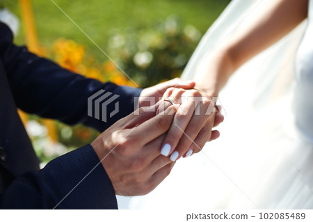 Wedding engagement rings. Newlywed couple's hands with engagement rings. Young couple at ceremony. 102085489