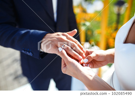Wedding engagement rings. Newlywed couple's hands with engagement rings. Young couple at ceremony. 102085490