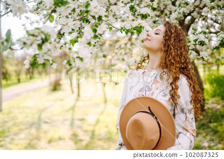 Smiling woman with hat in spring park. The concept of relax, travel, freedom. 102087325