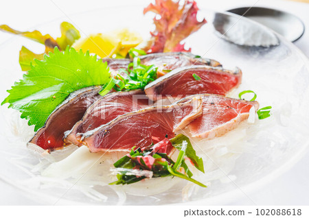 Seared bonito on a glass plate 102088618