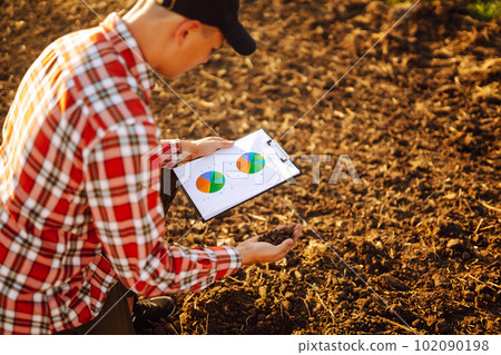 Hand of expert farmer collect soil and checking soil health before growth a seed of vegetable. 102090198