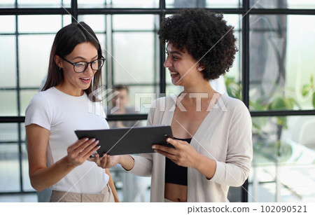 Two women analyzing documents office. Woman executives at work in office discussing some paperwork. 102090521