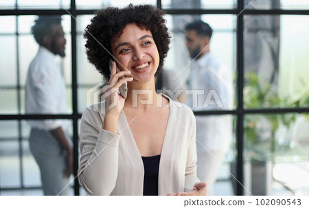 Businesswoman with phone in modern office 102090543