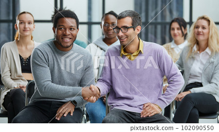 Happy multiethnic employees having fun while discussing project, sharing ideas, informal brainstorming sitting on chairs 102090550