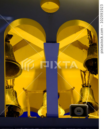 Greek orthodox church bells lit at night in a church in Preveza in Greece 102091923