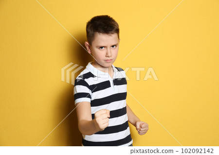 Portrait of emotional preteen boy on yellow background Portrait of emotional preteen boy on yellow background 102092142