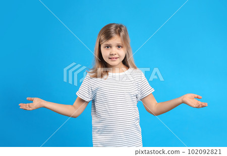 Emotional little girl on light blue background Emotional little girl on light blue background 102092821
