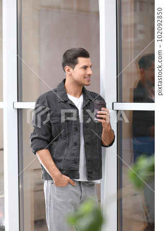 Handsome man with cup of coffee near window Handsome man with cup of coffee near window 102092850