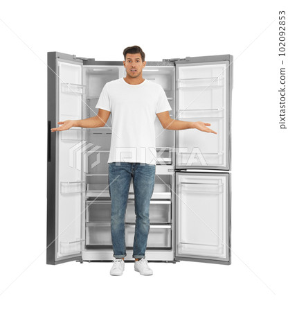 Man near open empty refrigerator on white background 102092853
