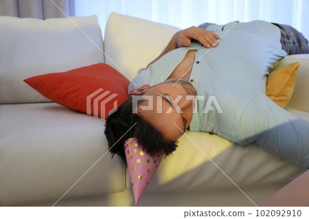 Young man sleeping on sofa in room after party Young man sleeping on sofa in room after party 102092910