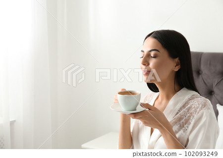 Woman with cup of coffee in bedroom. Lazy morning 102093249