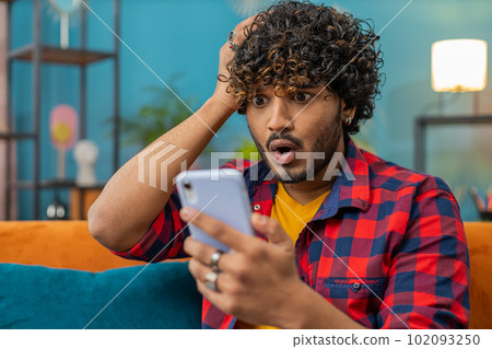 Sad indian man use smartphone surprised by bad news, fortune loss, fail, lottery results, deadline Sad indian man use smartphone surprised by bad news, fortune loss, fail, lottery results, deadline 102093250