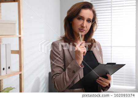 Portrait of psychotherapist with clipboard in office 102093374