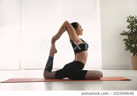 Woman practicing one legged king pigeon asana in yoga studio. Eka pada rajakapotasana Woman practicing one legged king pigeon asana in yoga studio. Eka pada rajakapotasana 102094646