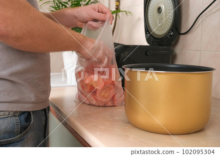A man puts frozen tomatoes cut into thin slices in 102095304