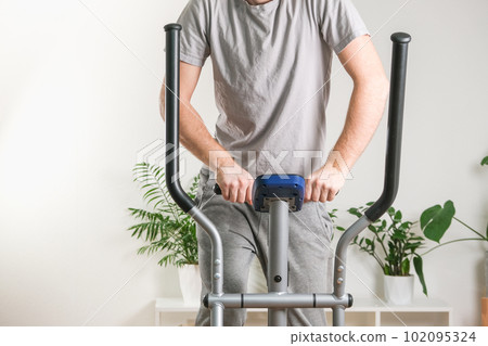 A man trains on an Elliptical Machine. Sports 102095324