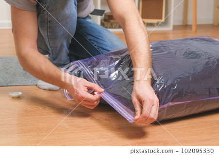 A man folds winter jackets and puts them in a 102095330