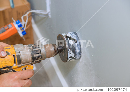 An electrical wire has to be installed in wall by drilling hole in drywall An electrical wire has to be installed in wall by drilling hole in drywall 102097474