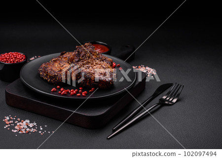 Delicious beef or pork steak on the bone grilled with spices and rosemary Delicious beef or pork steak on the bone grilled with spices and rosemary 102097494
