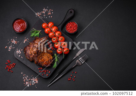 Delicious beef or pork steak on the bone grilled with spices and rosemary Delicious beef or pork steak on the bone grilled with spices and rosemary 102097512