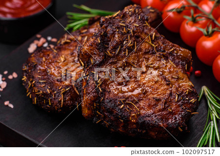Delicious beef or pork steak on the bone grilled with spices and rosemary Delicious beef or pork steak on the bone grilled with spices and rosemary 102097517