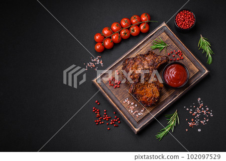 Delicious beef or pork steak on the bone grilled with spices and rosemary Delicious beef or pork steak on the bone grilled with spices and rosemary 102097529