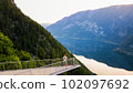 Young man standing on the viewing platform with drone controller view of Hallstatt lake, mountains 102097692