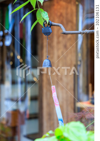 A wind chime hanging from a tree in front of the store A wind chime hanging from a tree in front of the store 102106131