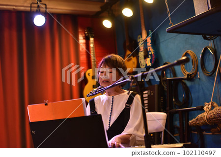 Female keyboardist of a blues band performing in a live house 102110497