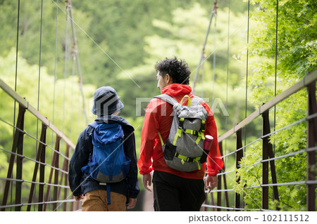 An image of a parent and child climbing a mountain surrounded by fresh greenery and beautiful greenery Leisure and outdoor activities Copy space available 102111512