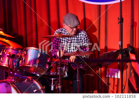 Blues band drummer playing in a live house 102111858