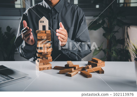 Hands stop domino effect before destroy home before fail, Hand of engineer man protection blocks wood tower, business risk and strategy dangerous project, Insurance concept Hands stop domino effect before destroy home before fail, Hand of engineer man protection blocks wood tower, business risk and strategy dangerous project, Insurance concept 102113976